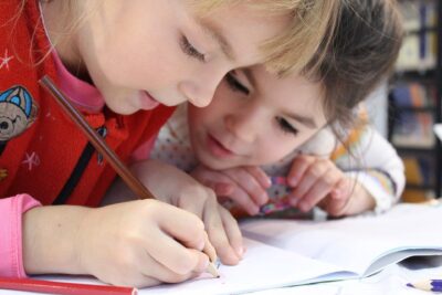 Två barn skriver i en skrivbok