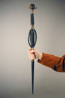 A hand holding a reconstruktion of a staff found in a womans grave